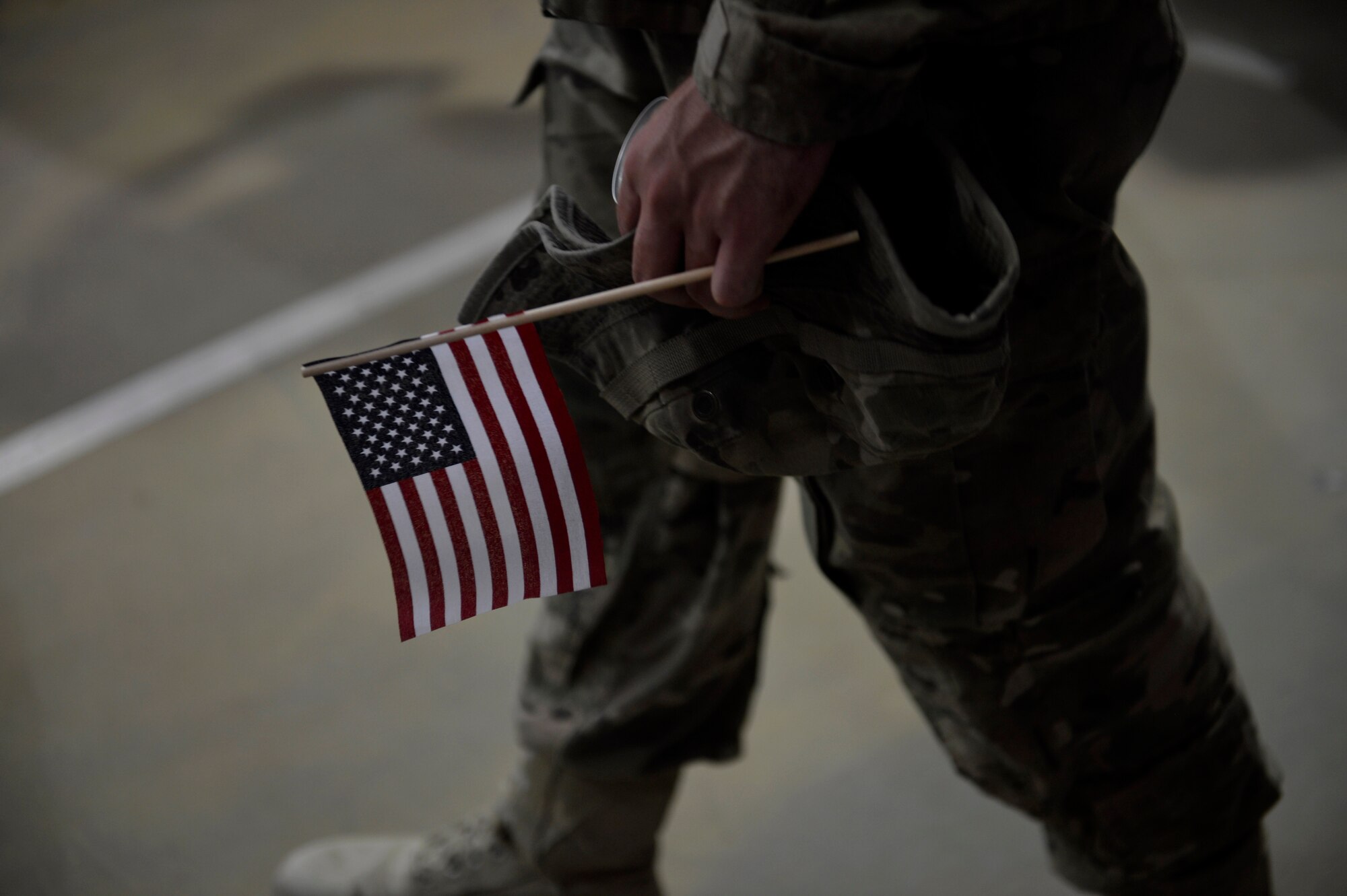 A U.S. service member carries an American flag during a Fourth of July celebration at Bagram Airfield, Afghanistan July 4, 2014.  Basketball, tug-of-war and volleyball were activities to enjoy during the holiday. (U.S. Air Force photo by Staff Sgt. Evelyn Chavez/Released)