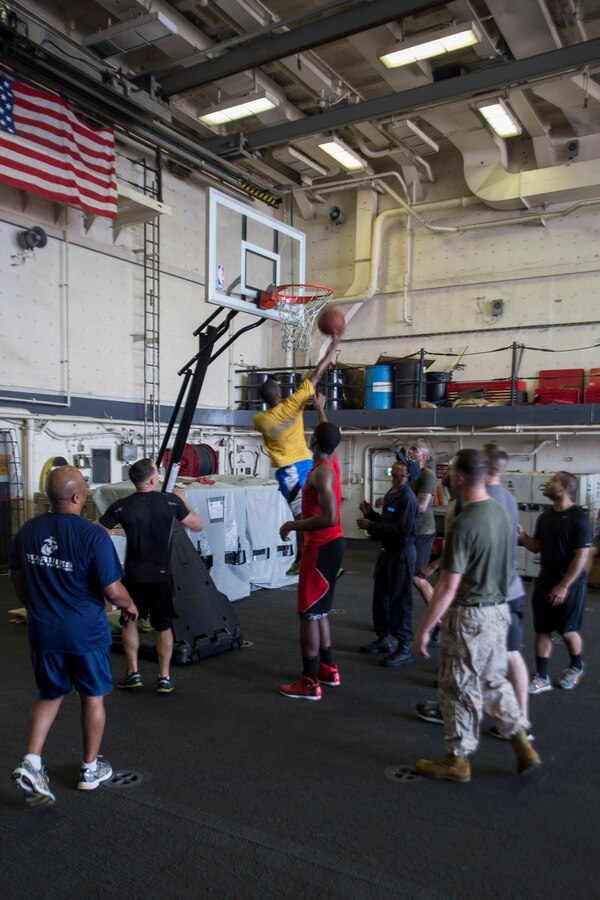 U.S. 5TH FLEET AREA OF RESPONSIBILITY (June 29, 2014) U.S. Marines with 22nd Marine Expeditionary Unit (MEU) and Sailors aboard the USS Mesa Verde (LPD 19) compete in a game of basketball inside the hangar bay during a steel beach picnic. The 22nd MEU is deployed with the Bataan Amphibious Ready Group as a theater reserve and crisis response force throughout U.S. Central Command and the U.S. 5th Fleet area of responsibility. (U.S. Marine Corps photo by Cpl. Manuel A. Estrada/Released)