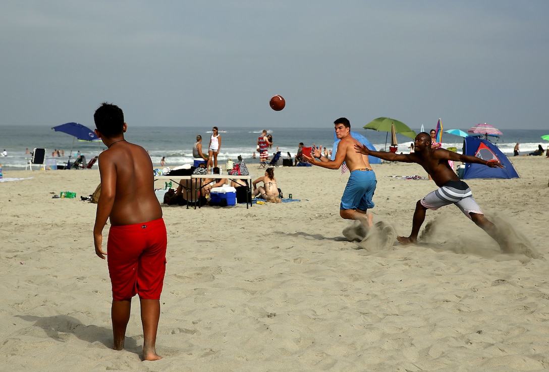 Jacob, 13  throws the football to Dakota Miller while Navy Airman Akira Burgess tries to intercept the ball during a football game at the Beach Bash at Del Mar Beach here July 4.  

The Beach Bash is an on-base event open to service members, dependents and guests and features  live bands, kids’ activities, a tribute to heroes video, a fireworks show and give-aways.

Burgess is an aviation ordnance technician on Naval Base Coronado, Calif.