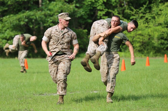 Lance Cpl. Jose Perez carries Lance Cpl. Samuel York during Marine Wing Support Squadron 271’s field meet at Marine Corps Air Station Cherry Point, N.C., June 27, 2014. Sergeant Spencer R. McKinstry ran alongside the Marines to motivate them and to keep their time. The competition consisted of a series of physical tests to challenge the Marines ability to work together efficiently. York is a combat engineer, Perez is an electrician and McKinstry is an engineer equipment operator, all members of MWSS-271.  