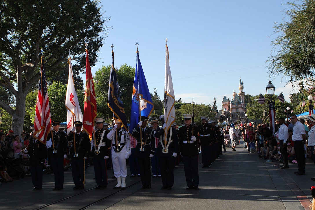 Service members present the American and military service flags during the parade portion of a special Fourth of July evening colors ceremony at the Disneyland Resort in Anaheim, Calif., July 4. Individual representatives from each branch of service marched with the 3rd Marine Aircraft Wing Band, which later performed a patriotic concert at the Big Thunder Ranch Jamboree stage. The 3rd MAW Band has performed at Disneyland on Independence Day for the past three years.