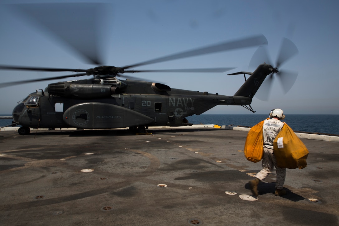 U.S. 5TH FLEET AREA OF RESPONSIBILITY (July 3, 2014) A U.S. Marine with amphibious transport dock ship USS Mesa Verde (LPD 19) combat cargo prepares to load bags of mail onto an MH-53E Sea Dragon with Helicopter Mine Countermeasures Squadron 15 (HM 15). The 22nd Marine Expeditionary Unit is deployed with the Bataan Amphibious Ready Group as a theater reserve and crisis response force throughout U.S. Central Command and the U.S. 5th Fleet area of responsibility. (U.S. Marine Corps photo by Cpl. Manuel A. Estrada/Released)