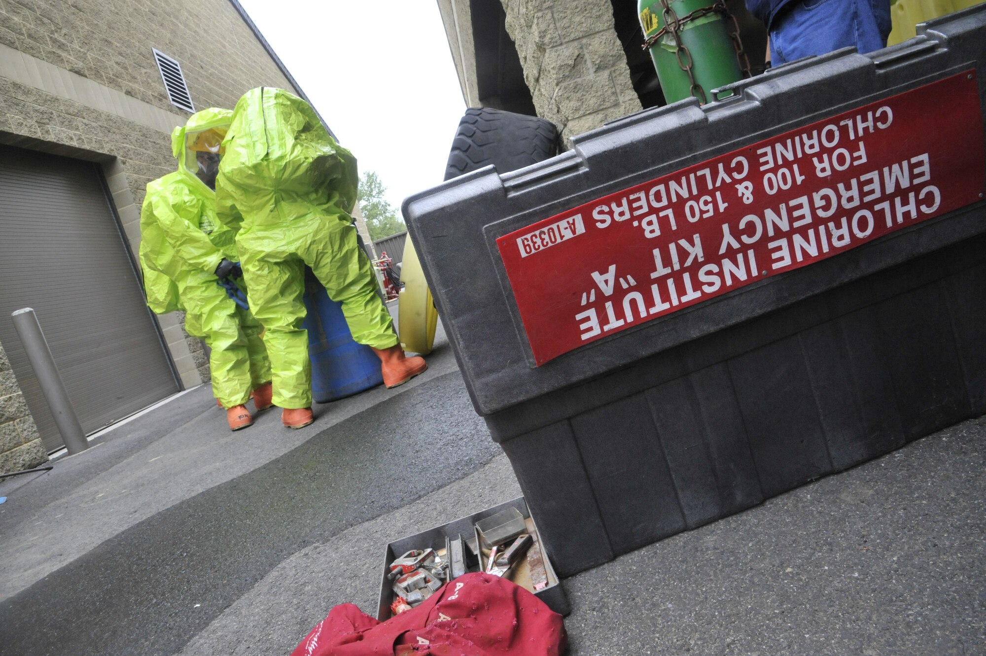First responders assess a "hazardous" leak during a training exercise at Fairchild Air Force Base, Washington, June 26, 2014. Firefighters from across the Air Force came to Fairchild to attend a hazardous materials technical training course designed to improve weapons of mass destruction and HazMat incident response capability.  After the 64-hour course, students  received certifications recognized by the International Fire Service Accreditation Congress. Students are also taught how to research a chemical's effect on the body, reactions with other chemicals and proper identification of personal protection equipment. (U.S. Air Force photo by Senior Airman Mary O'Dell/Released)