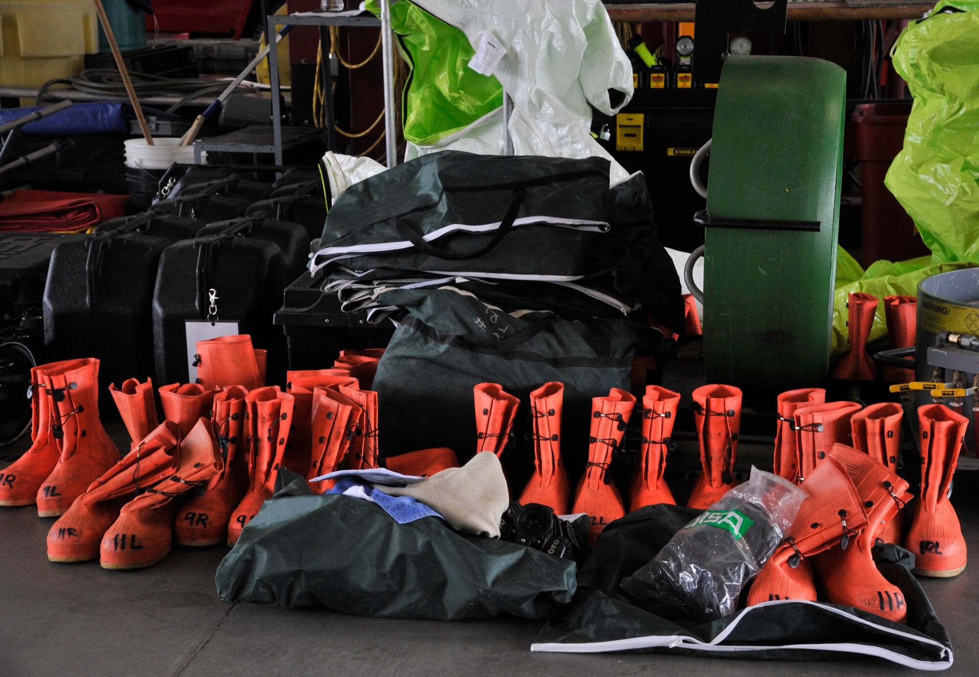 Equipment is gathered on the floor of the 92nd Civil Engineer fire department prior to a training course at Fairchild Air Force Base, Washington, June 26, 2014. Two instructors from the Louis F. Garland Fire Academy traveled to Fairchild with all of the equipment needed to teach Air Force firefighters and other first responders a course on hazardous material incident response and technical training. Students are also taught how to research a chemical's effect on the body, reactions with other chemicals and proper identification of personal protective equipment. The Louis F. Garland Fire Academy is located at Goodfellow AFB, Texas. (U.S. Air Force photo by Senior Airman Mary O'Dell/Released)