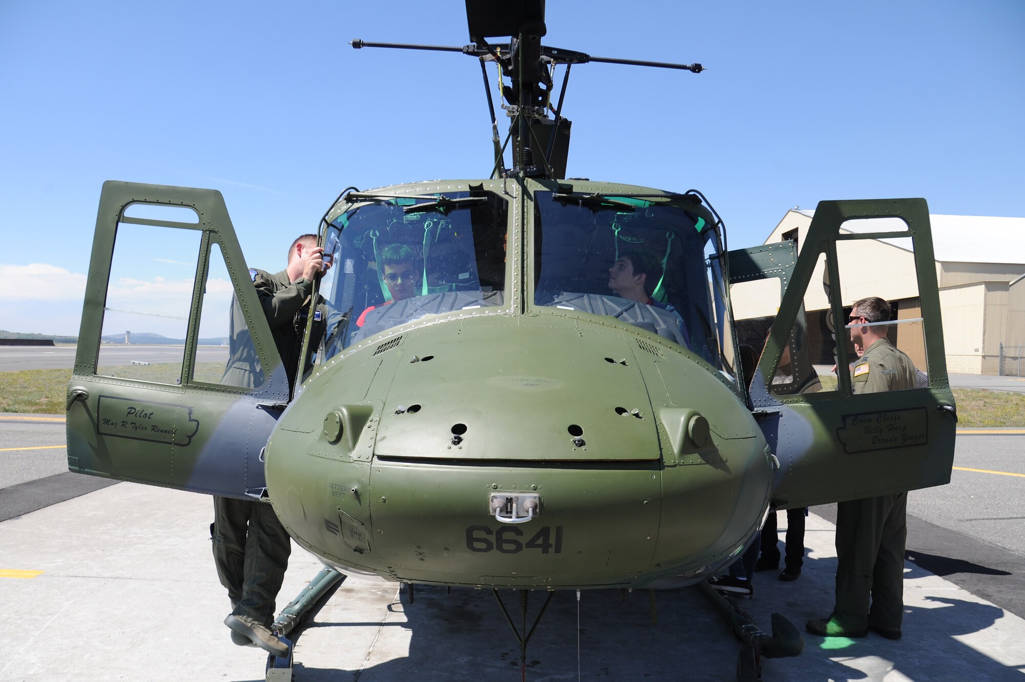Pilots from the 36th Rescue Flight show students from Spokane Community College a UH-1N Iroquois rescue helicopter during a base tour at Fairchild Air Force Base, Washington, July 2, 2014. The students received a base tour with stops at aerospace physiology, the control tower, a rescue helicopter static display, the base headquarters and the KC-135 Stratotanker flight simulator. (U.S. Air Force photo by Airman 1st Class Janelle Patiño/Released)