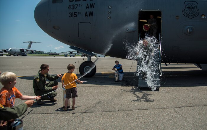 Col. Tony Schenk, 437th Operations Group deputy commander, is sprayed by friends and family July 1, 2014, on the flightline at Joint Base Charleston, S.C. Shenk just completed his ‘fini’ flight, an aviation tradition in which aircrew members are met by their unit comrades, family and friends and soaked with water after completing their final flight with that unit. (U.S. Air Force photo/ Airman 1st Class Clayton Cupit)