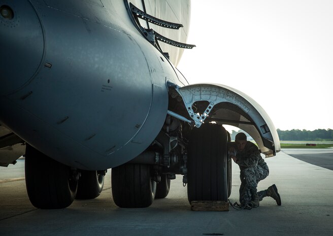 An Airman inspects the landing gear of a C-17 Globemaster III July 1, 2014, on the flight line at Joint Base Charleston, S.C. The maintainers perform checks and maintenance around the clock to ensure the aircraft are ready to fly. (U.S. Air Force photo/ Airman 1st Class Clayton Cupit)