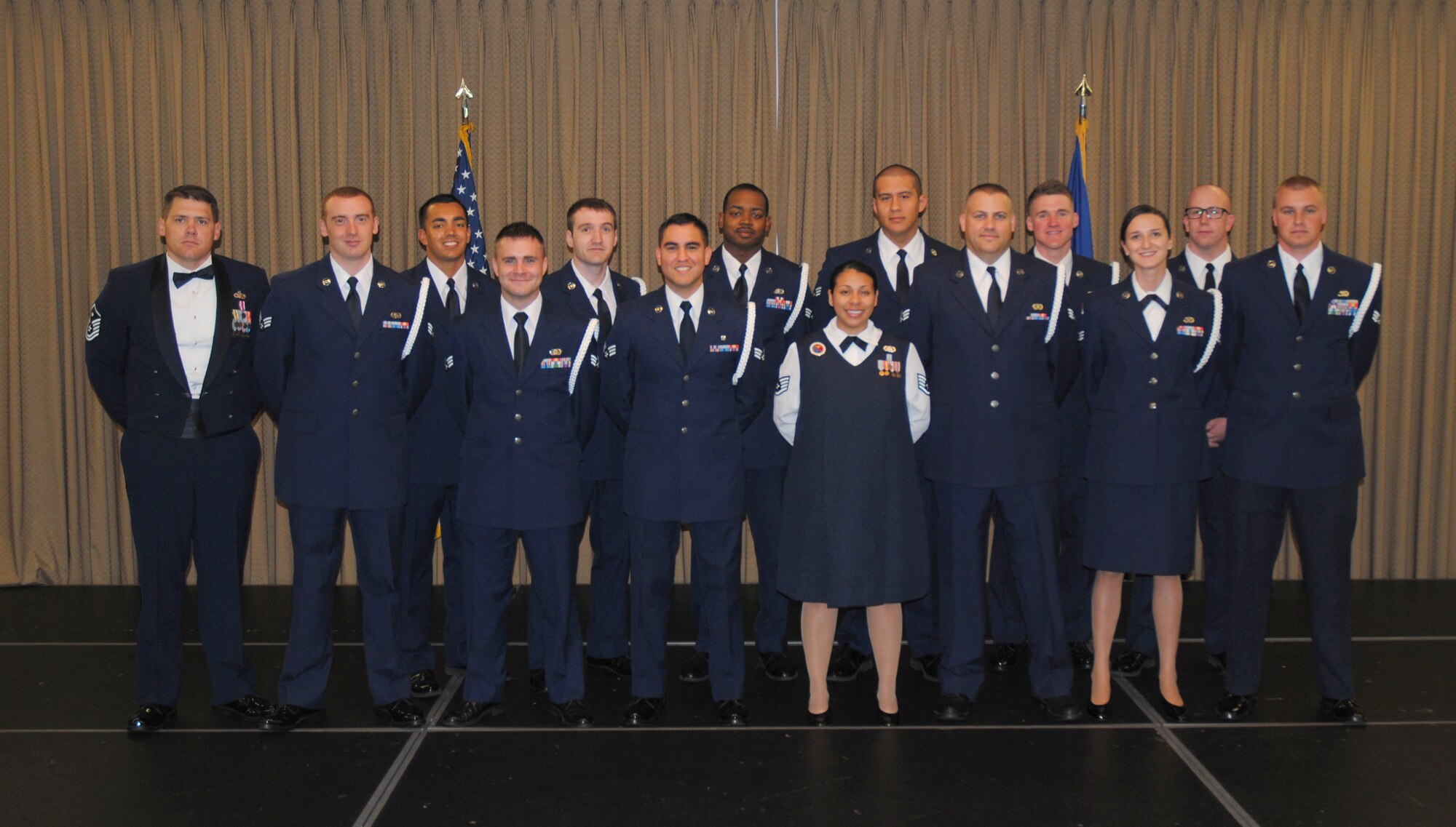 Chief Master Sgt. Richard L. Etchberger Airman Leadership School Class 14-Echo (active-duty members) pose for a group photo with their ALS instructor and class mentor moments before a graduation ceremony held June 26, 2014, at the Northern Lights Club on Grand Forks Air Force Base, N.D. Class 14-E was made up by two groups of students more commonly referred to in the Air Force as flights. One flight consisted of 12 active-duty Airmen completing their in-residence course at the Etchberger ALS in Grand Forks AFB, while the other flight was made up of a dozen Air National Guard Airmen from the 119th Wing attending an in-residence ALS course at the North Dakota ANG base in Fargo, N.D. Both of the flights were simultaneously taught by Air Force active-duty instructors from the Etchberger ALS. This new approach on training was the first of its kind according to officials from the 119th Wing and the 319th Air Base Wing. (U.S. Air Force photo/Staff Sgt. Luis Loza Gutierrez)