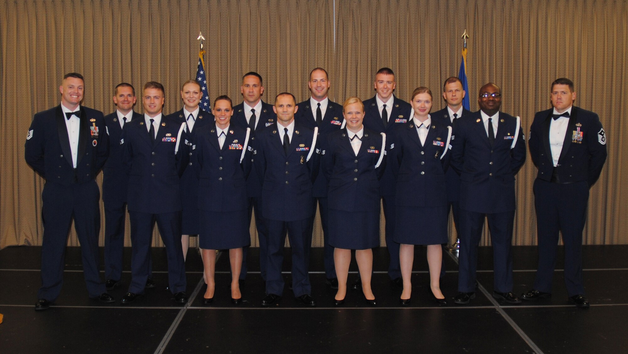 Chief Master Sgt. Richard L. Etchberger Airman Leadership School Class 14-Echo (Air National Guard flight) pose for a group photo with their ALS instructor and class mentor moments before a graduation ceremony held June 26, 2014, at the Northern Lights Club on Grand Forks Air Force Base, N.D. Class 14-E was made up by two groups of students more commonly referred to in the Air Force as flights. One flight consisted of 12 active-duty Airmen completing their in-residence course at the Etchberger ALS in Grand Forks AFB, while the other flight was made up of a dozen Air National Guard Airmen from the 119th Wing attending an in-residence ALS course at the North Dakota ANG base in Fargo, N.D. Both of the flights were simultaneously taught by Air Force active-duty instructors from the Etchberger ALS. This new approach on training was the first of its kind according to officials from the 119th Wing and the 319th Air Base Wing. (U.S. Air Force photo/Staff Sgt. Luis Loza Gutierrez)