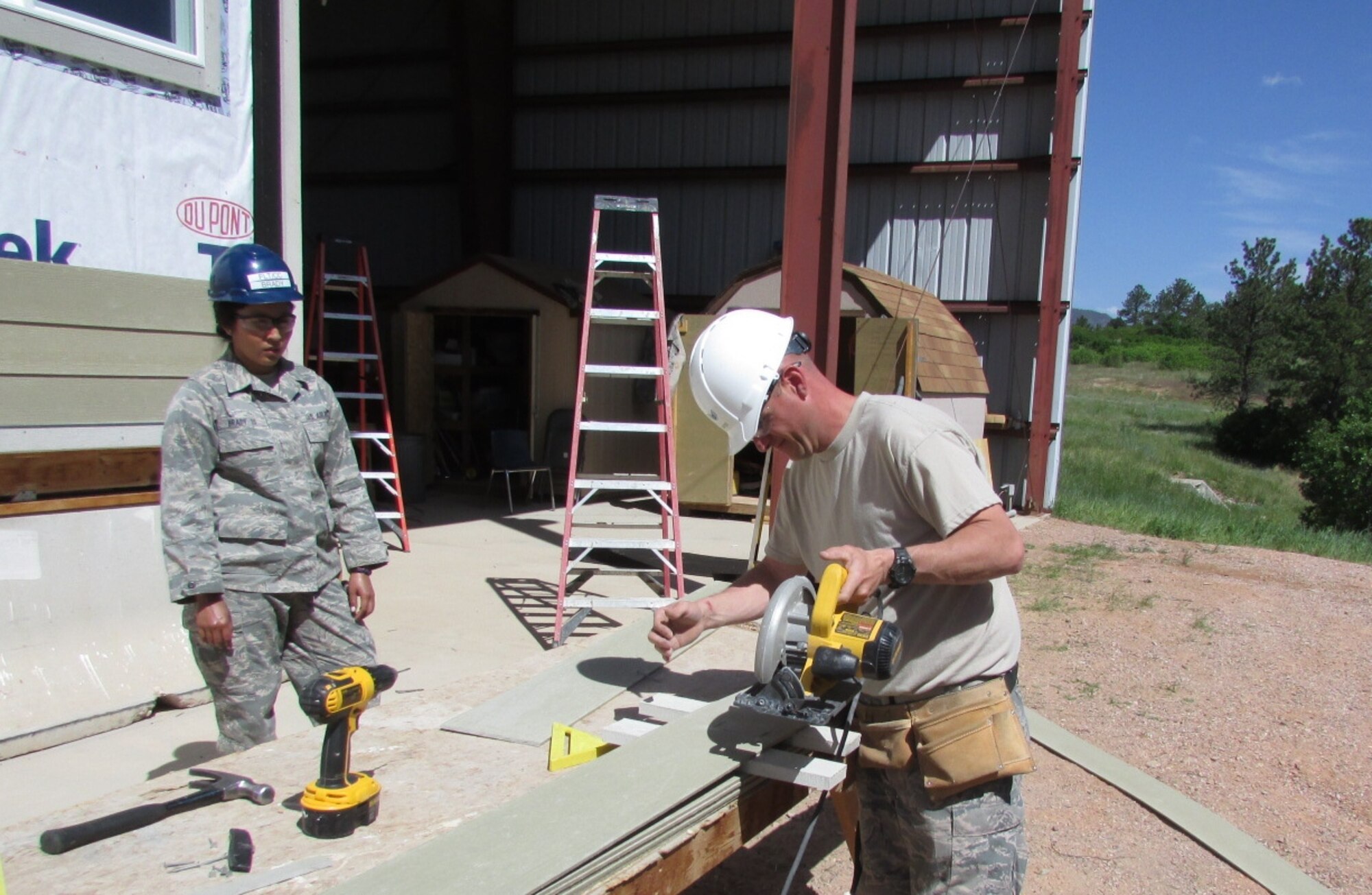 Staff Sgt. Jeffrey Butts, 914th Civil Engineer Squadron, structures, assists a cadet with siding installation on a Hogan Home at the Field Engineering & Readiness Laboratory site located at the Air Force Academy, Colorado Springs, Colorado on June 9, 2014. The 914 CES traveled to the USAFA for annual tour training and mentored more than 60 cadets with instruction and hands-on training.  (U.S. Air Force photo by Senior Master Sgt. Michael Haag)