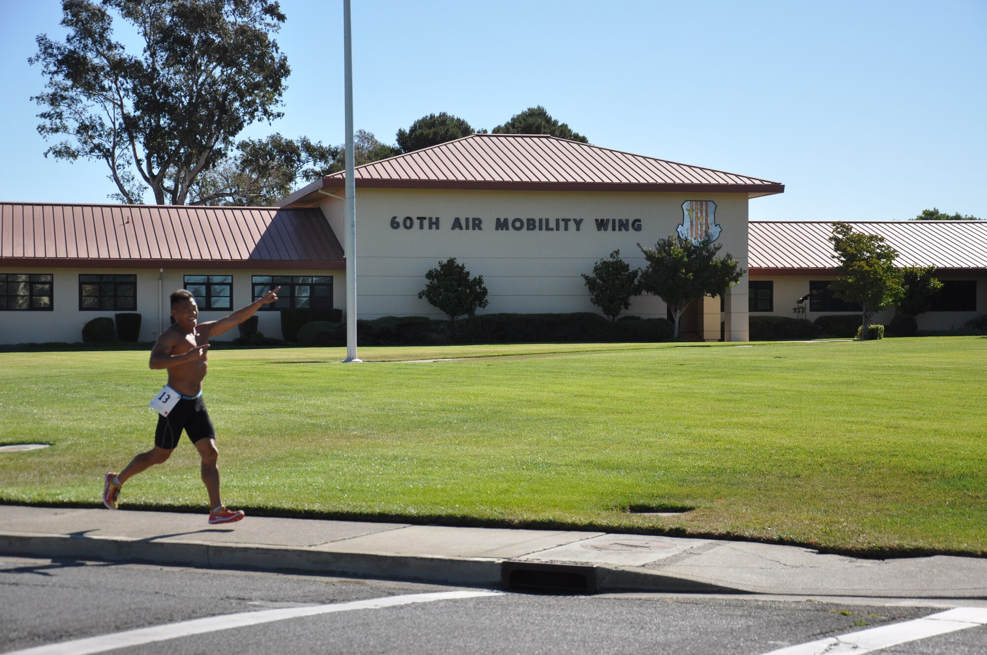 A participant runs on Burgan Boulevard in front of 60th Air Mobility Wing headquarters during the 3.6 mile run portion of the triathlon. The run was the last obstacle to complete after a 500-meter swim and 12-mile bike ride. 