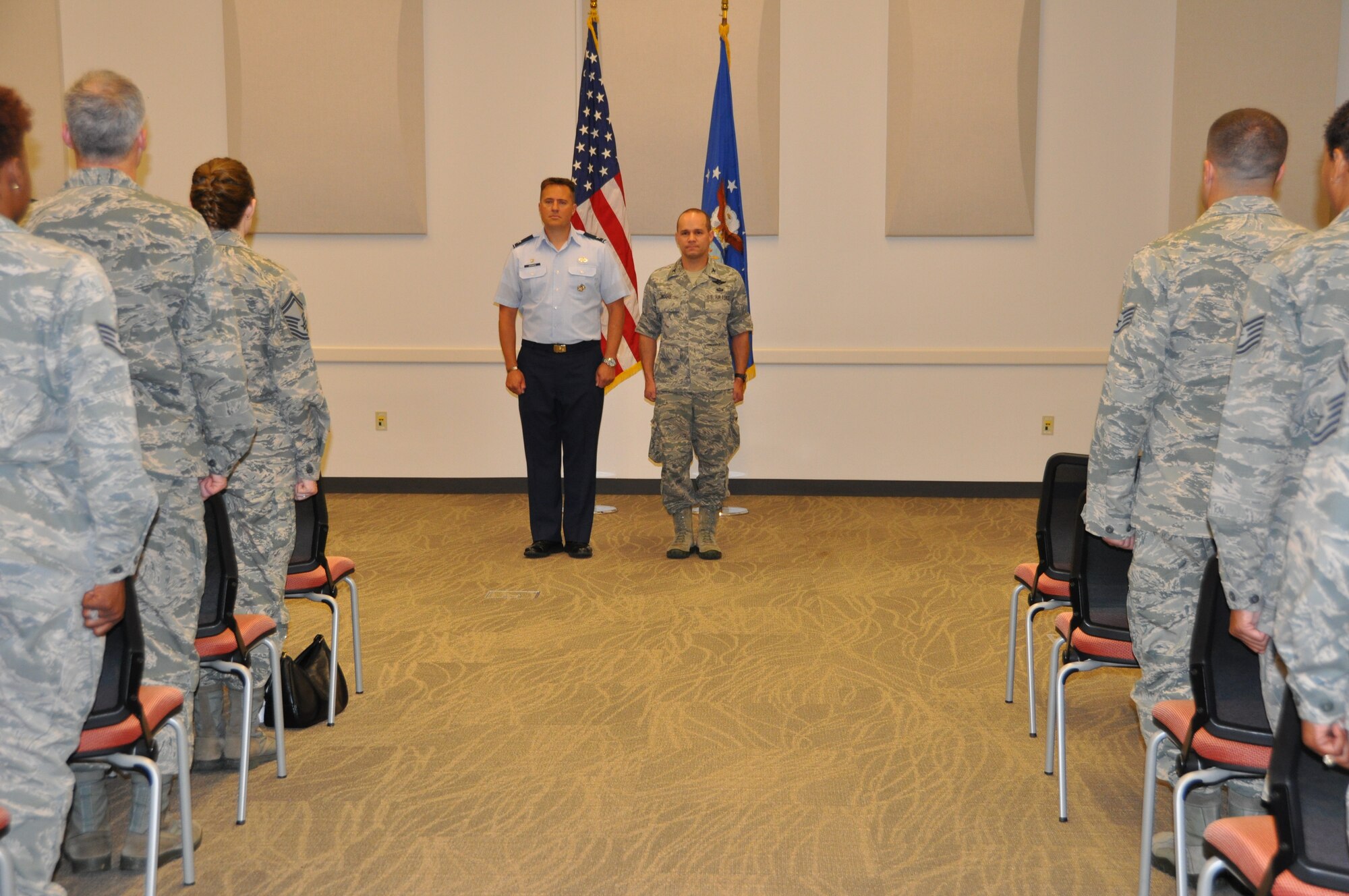 ROBINS AIR FORCE BASE, Ga. - Col. Christopher Cronce, commander of Headquarters Readiness and Integration Organization at Buckley Air Force Base, Colo., stands at attention with Col. Jeffrey Moore, program manager for Detachment 29, while the narrator reads the meritorious service medal citation during the first RIO commander’s call here July 2. Cronce conducted medal presentations and delivered his expectations to 70 RMG members, to include detachment program managers and superintendents. HQ RIO was activated Feb. 1, 2014 at Buckley AFB as a subordinate organization to ARPC because of the A1 Transformation. When fully operational, it will integrate more than 7,000 Air Force Reserve individual reservists into active-duty units to meet Air Force and combatant commander requirements. The commander’s call followed the inactivation ceremony of the Readiness Management Group. (US Air Force photo/Capt Candice Allen)