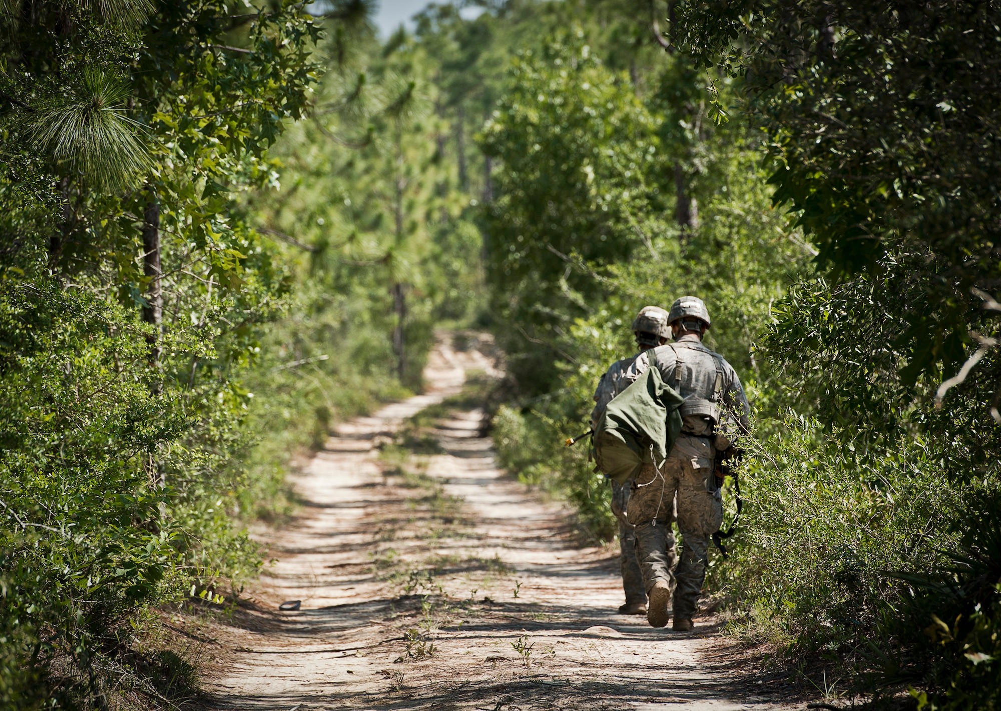 Army Ranger students return to their camp after collecting water during some down time in the woods of the Eglin Air Force Base, Fla., range.  Students complete the final phase of the Army Ranger course with the 6th Ranger Training Battalion.  Instructors expose the students to an 18-day field training that includes airborne and helicopter assaults, small boat operations, river and swamp crossings.  (U.S. Air Force photo/Tech. Sgt. Samuel King Jr.)