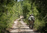 Army Ranger students return to their camp after collecting water during some down time in the woods of the Eglin Air Force Base, Fla., range.  Students complete the final phase of the Army Ranger course with the 6th Ranger Training Battalion.  Instructors expose the students to an 18-day field training that includes airborne and helicopter assaults, small boat operations, river and swamp crossings.  (U.S. Air Force photo/Tech. Sgt. Samuel King Jr.)