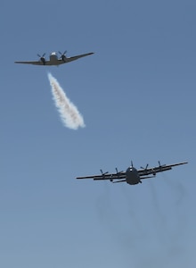 A U.S. Forest Service lead plane blows smoke to signal a Modular Airborne Fire Fighting System-equipped C-130 from the Wyoming Air National Guard's 153rd Airlift Wing that it's time to drop its payload during annual MAFFS training, near Cheyenne, Wyoming, on May 1, 2014. 