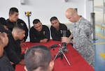 U.S. Army Sgt. Daniel Garcia-Benedetti, a small arms repairman in the 742nd Support Maintenance Company, South Carolina National Guard, teaches Colombian army maintenance workers how to troubleshoot malfunctions and break down an M240 machine gun, June 2014. 