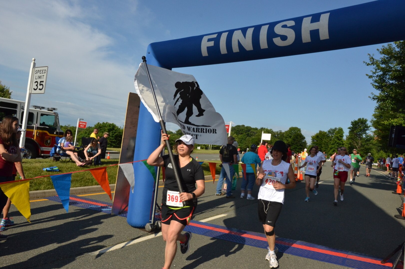 Runners cross the finish line at the 4 the Wounded 5K race in Charlottesville, Va., June 7. 
