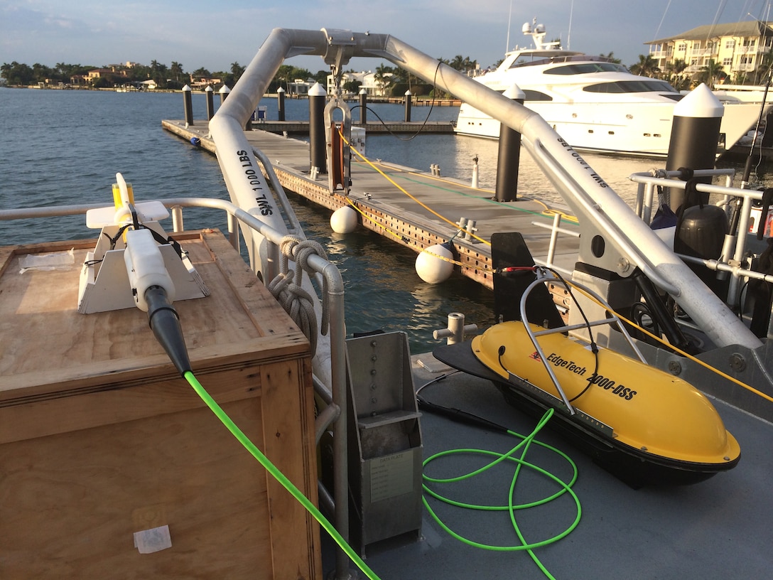 The large yellow capsule is the Edgetech 2000DS, which houses the side scan sonar and sub-bottom profiler. The side scan sonar sees the surface of the ocean floor and the sub-bottom profiler detects features just beneath the surface. Attached to this equipment via the green cable is the magnetometer, which is like a metal detector that picks up ferrous materials above and below the surface of the ocean floor, particularly ship hulls, ship elements, fittings, cannons, anchors and more.