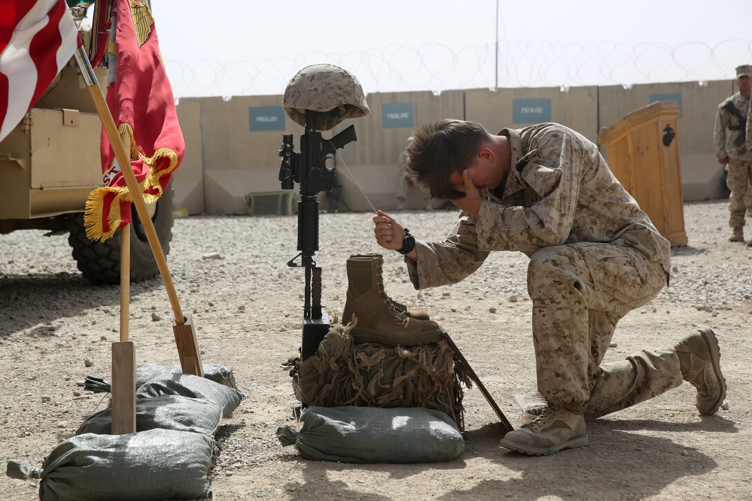 Petty Officer Third Class Jordan Lowe, corpsman, Scout Sniper Platoon, 1st Battalion, 7th Marine Regiment, pays his respects to Sgt. Thomas Z. Spitzer during a memorial ceremony aboard Camp Leatherneck, July 2, 2014. The memorial was in honor of Spitzer, a professionally instructed gunman with Scout Sniper Platoon, 1st Bn., 7th Marines, who was killed while conducting combat operations in Helmand province, Afghanistan, June 25, 2014.
(U.S. Marine Corps photo by Cpl. Joseph Scanlan / released)
