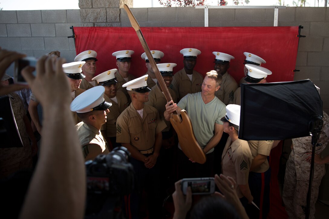 MARINE CORPS AIR STATION MIRAMAR, Calif. – Gary Sinise, actor and musician with the Lt. Dan Band, receives a gift from noncommissioned officers with Marine Aircraft Group (MAG) 16 before a concert aboard Marine Corps Air Station Miramar, Calif., July 7. Noncommissioned officers from MAG-16 organized the event with Sinise, which included a live performance with his band and a colors ceremony.