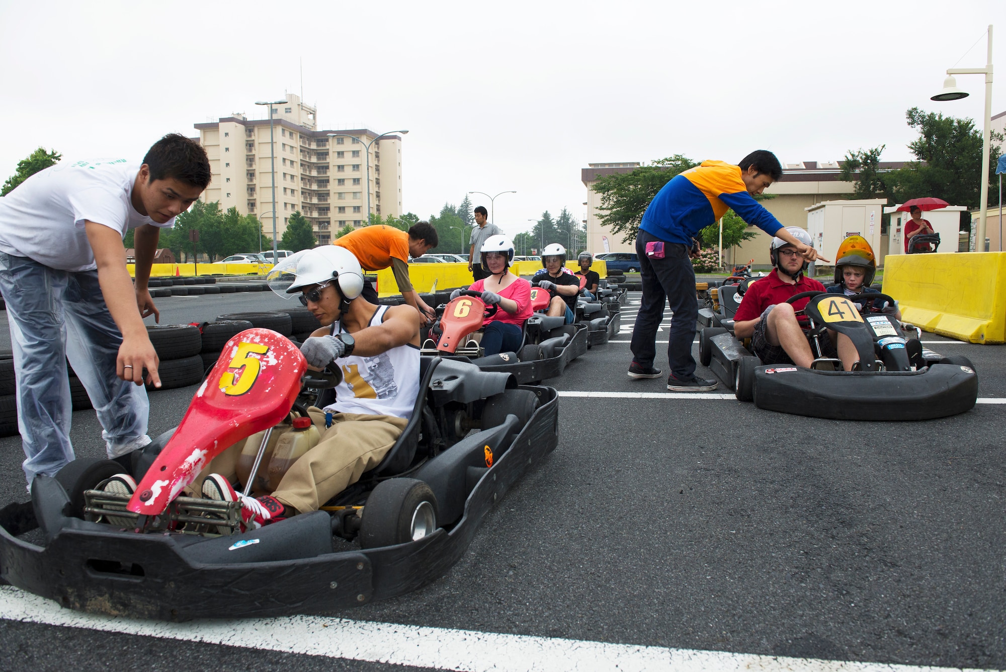 Operators of the go-kart track ensure drivers are strapped in before starting the engines during Celebrate America, a daylong 4th of July event coordinated by the 374th Force Support Squadron.  The event is held annually at Yokota Air Base, Japan, and features a number of events and games for military members and their families assigned to the installation.  (U.S. Air Force photo by Tech. Sgt. Christopher Marasky)