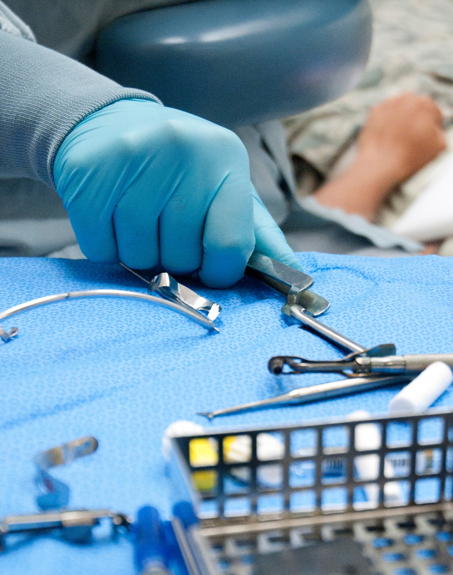 Airman 1st Class Tristan Crosswhite, 90th Medical Operations Squadron dental technician, reaches for dental equipment July 8, 2014, at the 90th MDG Medical Treatment Facility on F.E. Warren Air Force Base, Wyo. Crosswhite is assisting Capt. Trent Buttars, 90th Medical Operations Squadron dentist, with a cavity filling procedure. (U.S. Air Force photo by Airman Malcolm Mayfield)