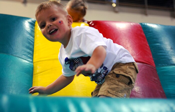 Peyton makes his way through an inflatable jungle gym, during Freedom Fest July 3, 2014 at Nellis Air Force Base Nev. Freedom Fest was hosted by the 99th Force Support Squadron and provided families the opportunity to mingle and celebrate before the four day weekend. (U.S. Air Force photo by Airman 1st Class Rachel Loftis)