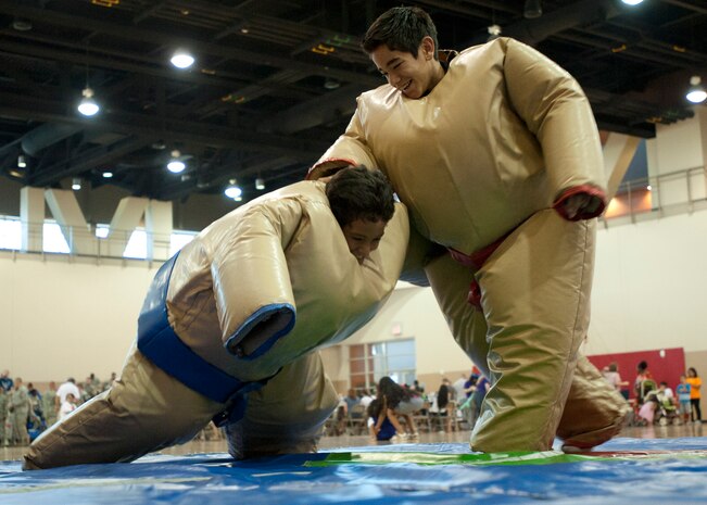 Kapaka (red) knocks down his brother Ma’ila while participating in padded sumo wrestling during Freedom Fest July 3, 2014 at Nellis Air Force Base Nev. This was one of the many events offered for children during the 99th Force Support Squadron’s sponsored festival. The event was held to celebrate the upcoming Independence Day. (U.S. Air Force photo by Senior Airman Timothy Young)