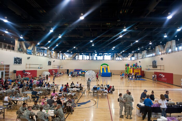 Airmen and their families gather for fun and food during Freedom Fest, hosted by the 99th Force Support Squadron, at the Warrior Fitness Center, July 3, 2014, at Nellis Air Force Base, Nev. The festival featured various games and activities for young children, such as inflatable slides, music for all participants to enjoy and traditional 4th of July food including grilled hotdogs and hamburgers. (U.S. Air Force photo by Airman 1st Class Thomas Spangler)