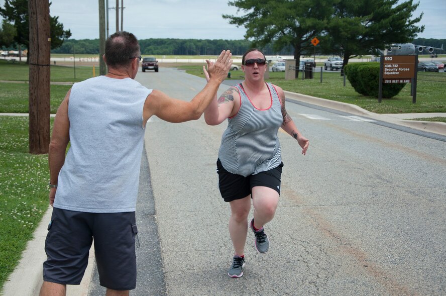 Airman 1st Class Kendra Valitchka, 736th Aircraft Maintenance Squadron C-17 Globemaster III crew chief, high-fives John Walters, 436th Aerospace Medicine Squadron fitness program manager, after running a 5K June 27, 2014, on Dover Air Force Base, Delaware. Since starting the 90 in 90” program in January, Valitchka has dropped 2 minutes off her 1.5 mile runtime. (U.S. Air Force photo/Senior Airman Jared Duhon) 

