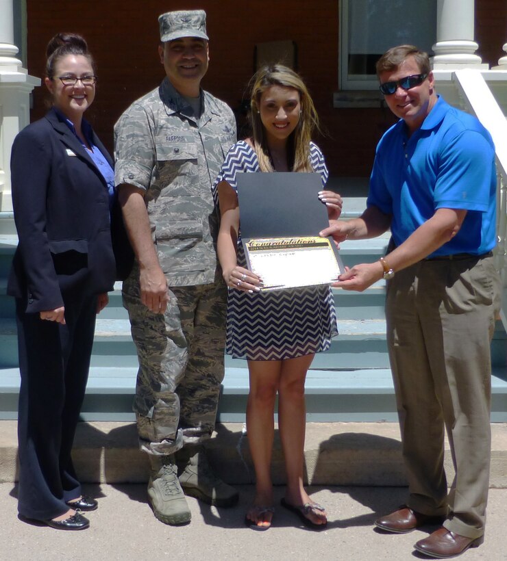 Anna Ulibarri, BBC concierge (far left) and Barrett Larwin, Balfour Beatty Communities regional vice-president (far right) presents Alison De la Concepcion (middle right) with a scholarship from the BBC Foundation while her father, Col. George Farfour stands by. 