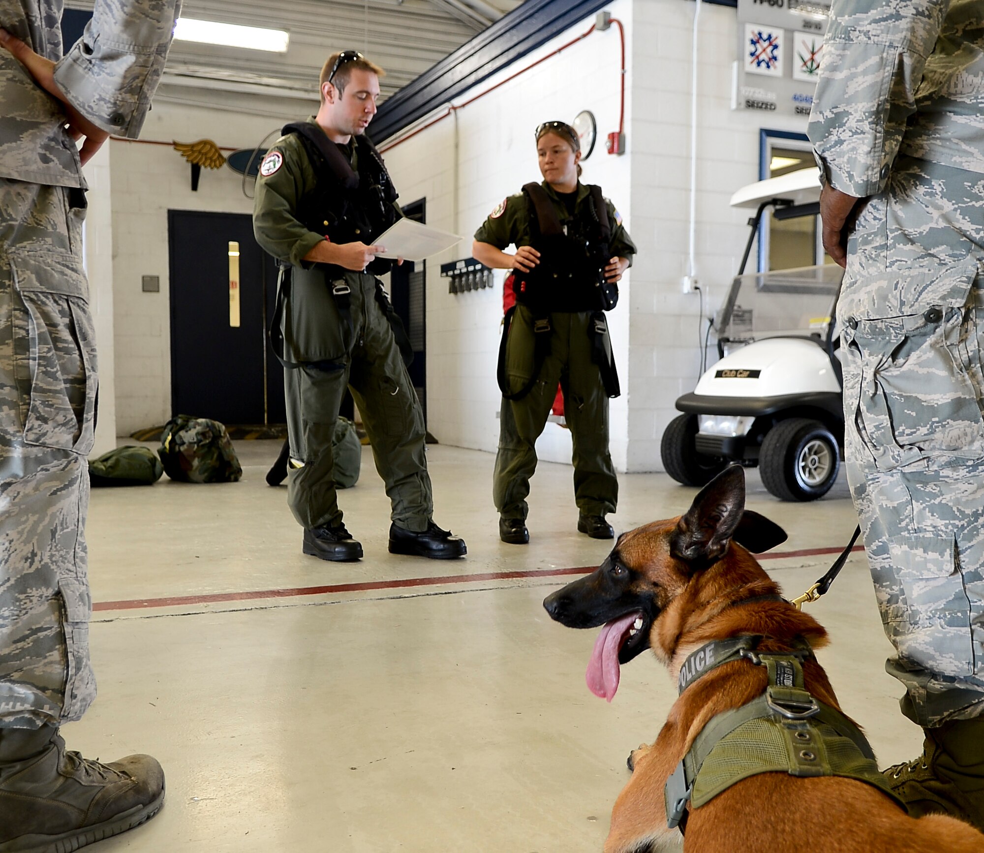 Handlers from the 6th Security Forces Squadron military working dog section and their dogs receive a brief from the Sikorsky MH-60T Jayhawk pilots prior to a training helicopter ride with the U.S. Coast Guard Air Station in Clearwater, Fla., June 30, 2014. This was the first time the MWD section and the Coast Guard have conducted this type of training, and will not be the last. (U.S. Air Force photo by Senior Airman Melanie Bulow-Gonterman/Released)