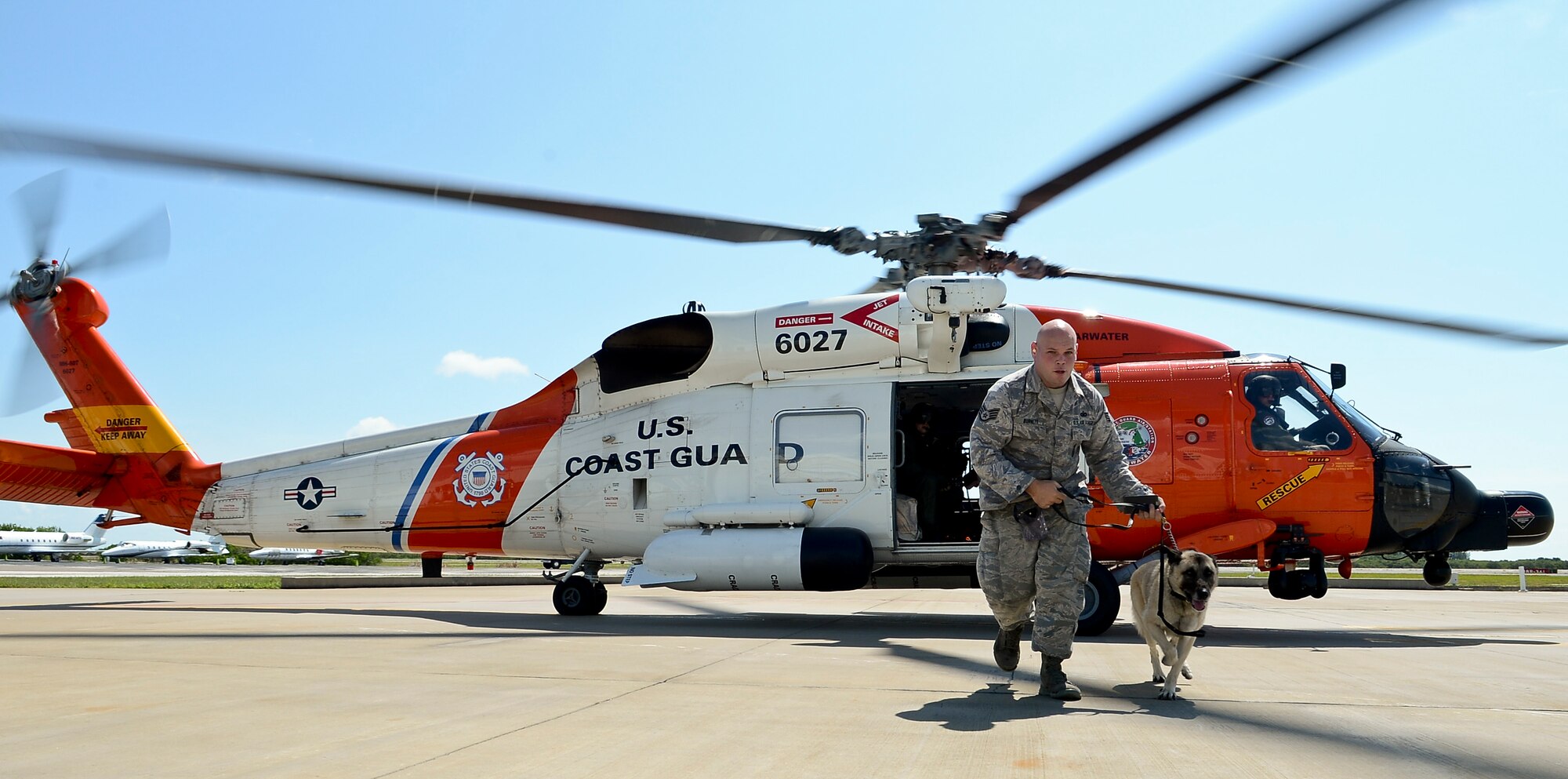 Staff Sgt Josh Burnett, 6th Security Forces Squadron military working dog handler, and MWD Jecky vacate the Sikorsky MH-60T Jayhawk during a training session with the U.S. Coast Guard Air Station in Clearwater, Fla., June 30, 2014. This was Jecky’s first time being exposed to the loud noise of helicopter along with the high altitude. (U.S. Air Force photo by Senior Airman Melanie Bulow-Gonterman/Released)