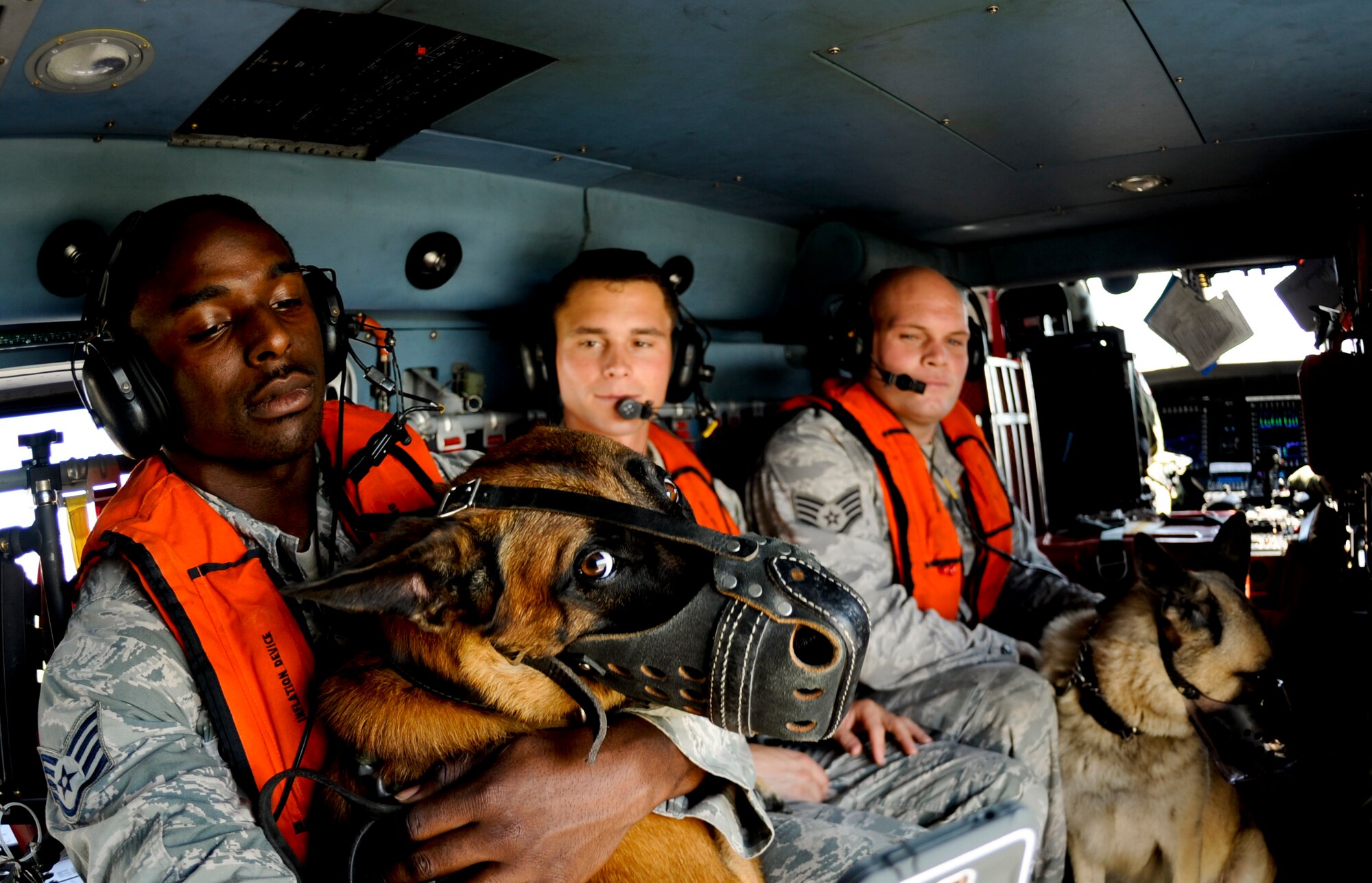 Staff Sgt. Winston Campbell, 6th Security Forces Squadron military working dog handler, comforts MWD Lleonard during a training helicopter ride with the U.S. Coast Guard Air Station in Clearwater, Fla., June 30, 2014. This was Lleonard’s first time being exposed to the noise of a helicopter along with the high altitude. (U.S. Air Force photo by Senior Airman Melanie Bulow-Gonterman/Released)