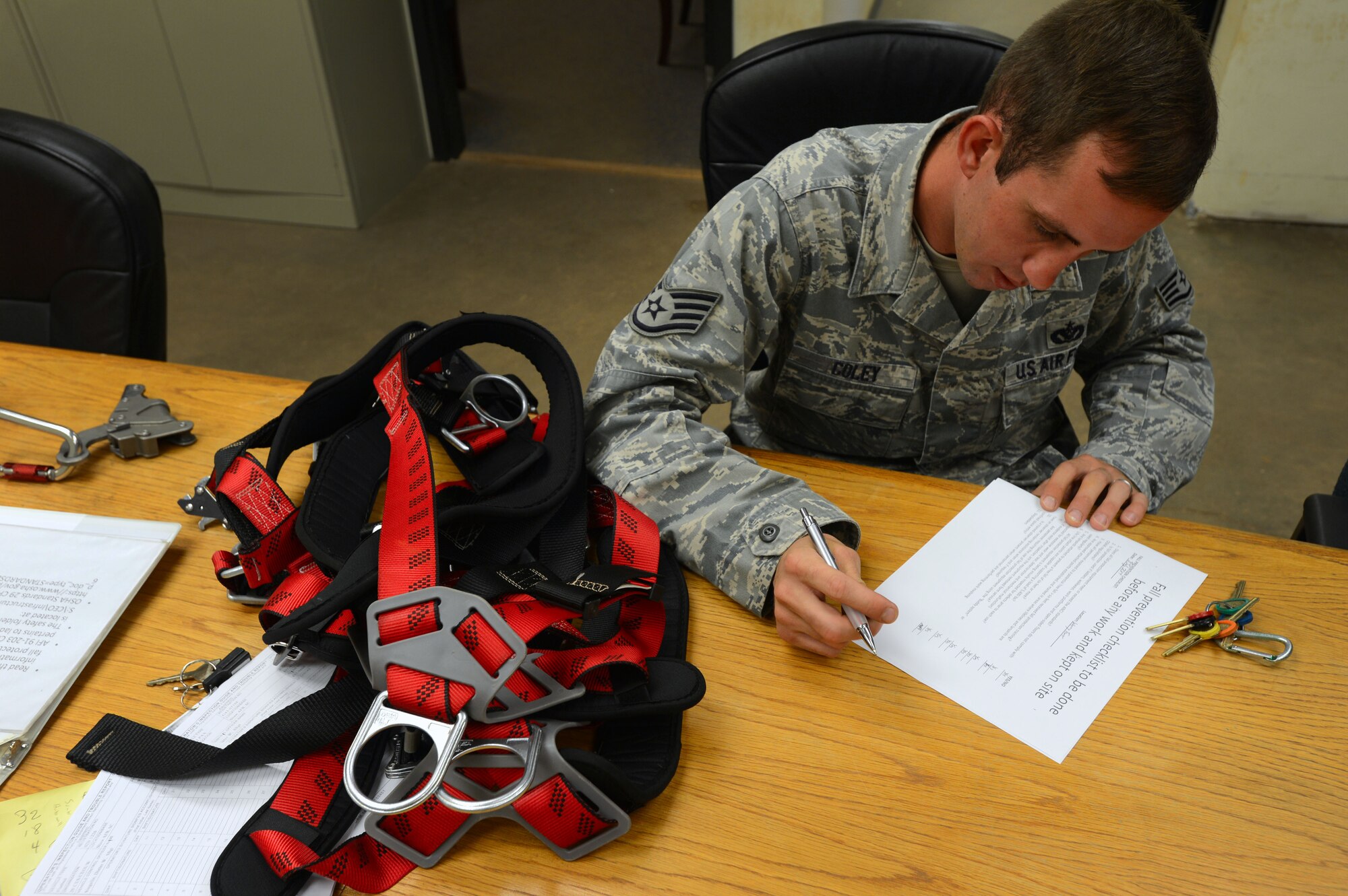 U.S. Air Force Staff Sgt. Phillip Coley, 20th Civil Engineer Squadron water and fuels systems maintenance craftsman, completes a pre-climb safety checklist at Shaw Air Force Base, S.C., July 8, 2014. Coley, along with all WFSM airmen, completes yearly fall protection training to ensure safety while climbing and inspecting water towers. (U.S. Air Force photo by Airman 1st Class Jensen Stidham/Released)
