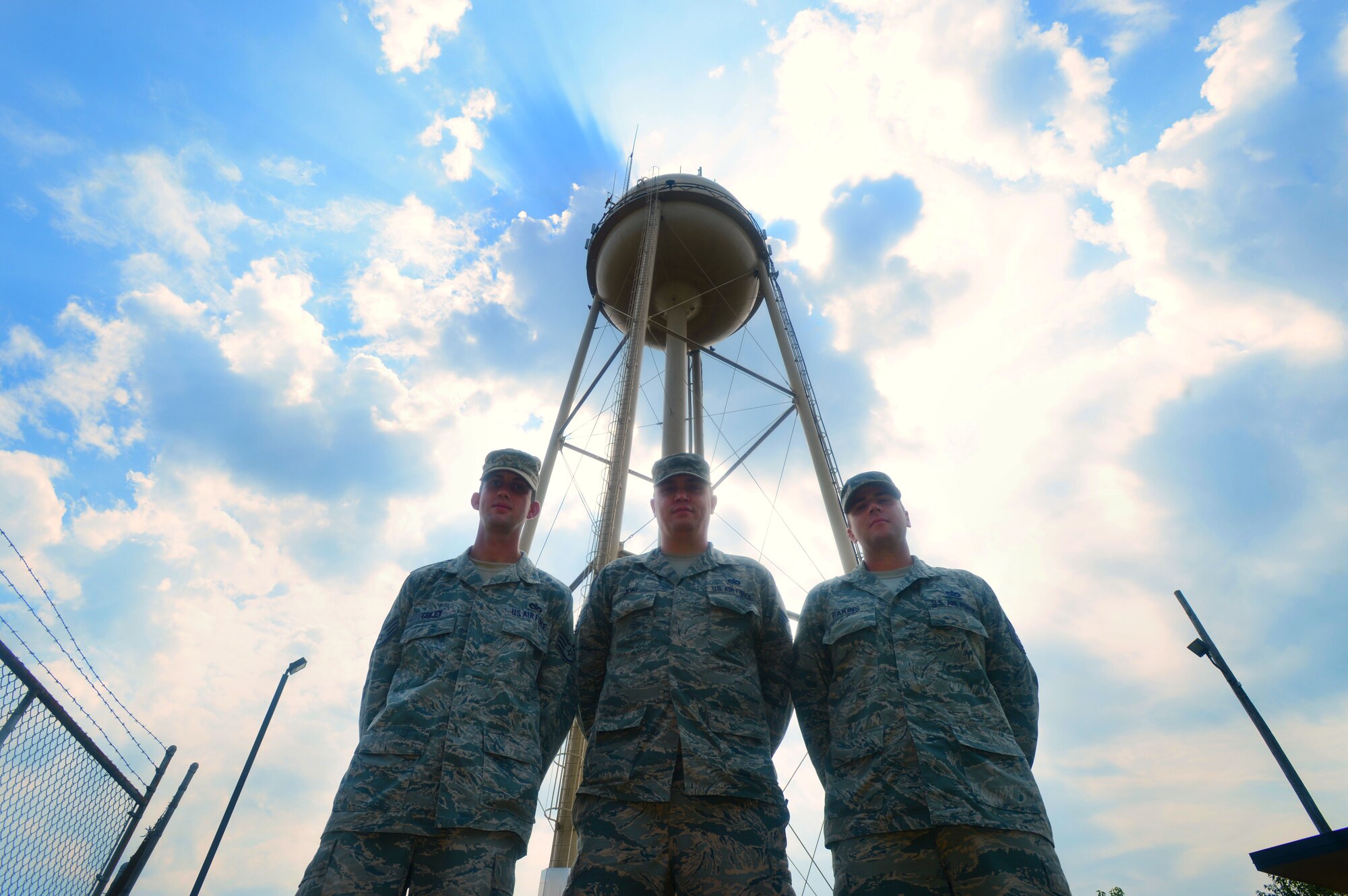 [From left] U.S. Air Force Staff Sgt. Phillip Coley, 20th Civil Engineer Squadron water and fuels systems maintenance craftsman, Staff Sgt. Brian Joki, 20th CES water operations supervisor, and Tech. Sgt. Christopher Eakins, 20th CES WFSM craftsman, stand in front of a water tower at Shaw Air Force Base, S.C., July 8, 2014. Handling more than half a million feet of gas, sewer and water lines, these three Airmen along with 21 additional Airmen maintain all water, gas and sewer related items. U.S. Air Force photo by Airman 1st Class Jensen Stidham/Released)