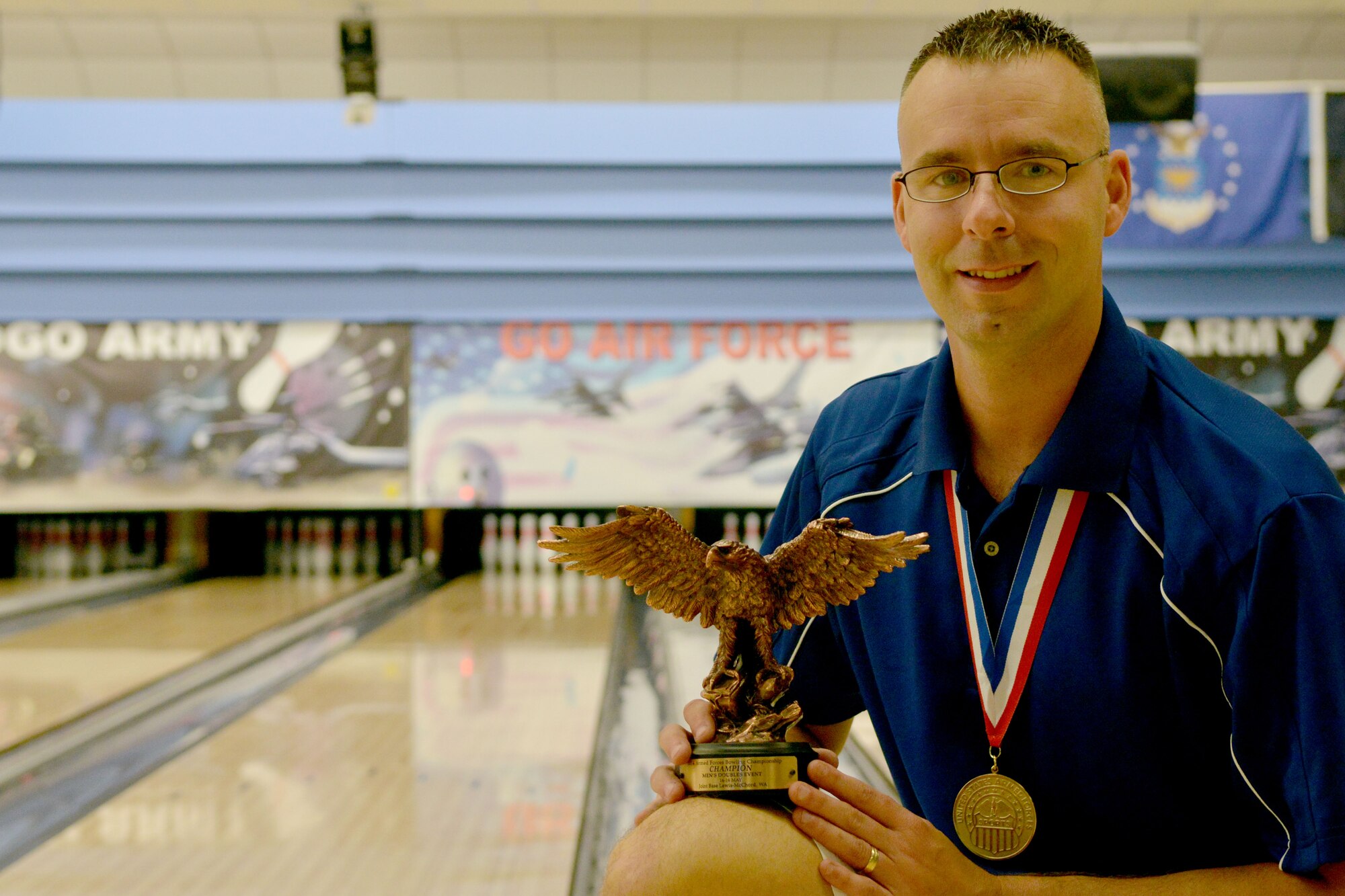 U.S. Air Force Staff Sgt. Charles Kropog, 20th Civil Engineer Squadron unit deployment manager, takes a photo infront of the bowling lanes at Shaw Air Force Base, S.C., July 1, 2014, Kropog participated in an annual Department of Defense Bowling tournament from May 11 to 17 . (U.S. Air Force photo by Senior Airman Ashley Gardner/Released)