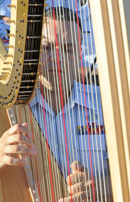 Senior Master Sergeant Eric Sabatino plays the harp during the United States Air Force Band's Independence Day Concert at the Air Force Memorial, July 4, 2014.  After the performance, show attendees viewed the National Fireworks Show. (U.S. Air Force photo/ Senior Airman Mariah Haddenham)