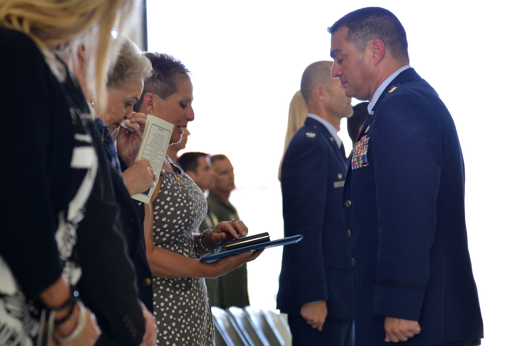 Roxanne Prine, mother of the late U.S. Air Force Senior Airman James Prine, accepts the Air Force Achievement Medal from Maj. Ivan Pennington, 1st Aircraft Maintenance Squadron commander, during a memorial service at Langley Air Force Base, Va., July 3, 2014. Senior Airman Prine, a 1st AMXS crew chief, died at the age of 23 in an accidental drowning and is survived by his mother, father, sister and other relatives. (U.S. Air Force photo by Senior Airman Aubrey White/Released)