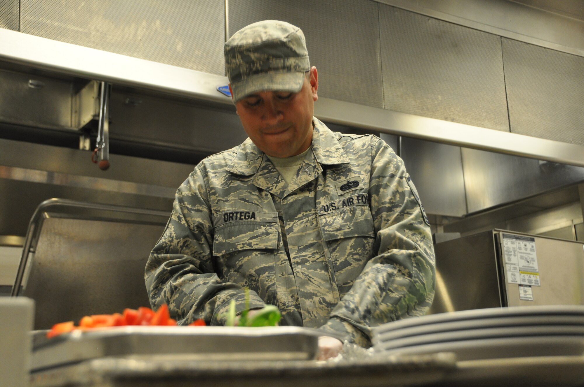 Master Sgt. Richard Ortega of the 92nd Communications Squadron prepares one of his team’s dishes during the cooking competition at Fairchild Air Force Base, Washington, June 25, 2014. Ortega was a member of the Top 3 organization team, which was the event winner. (U.S. Air Force photo by Staff Sgt. Robert Conniff/Released)