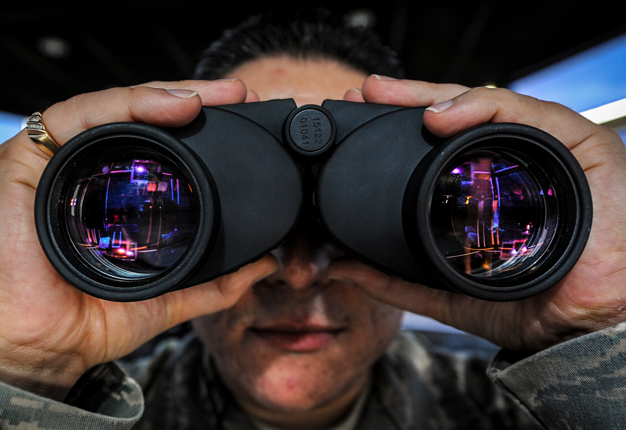 Tech. Sgt. Robert Aragon, 5th Operations Support Squadron air traffic control watch supervisor, looks through binoculars from the control tower on Minot Air Force Base, N.D., May 20, 2014. Aragon is checking for any obstructions on the ground, and scanning the sky for birds to ensure the safety of aircraft during taxi, take-off, and landing. (U.S. Air Force photo/Senior Airman Stephanie Morris)