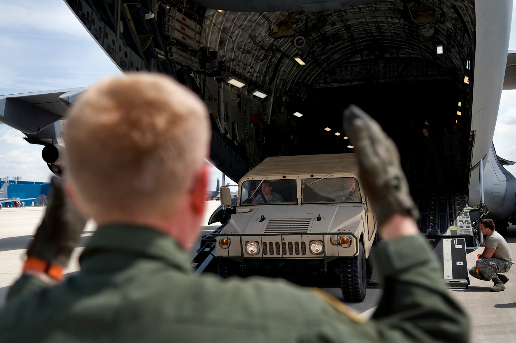 U.S. Air Force Master Sgt. David White, 89th Airlift Squadron loadmaster, directs Soldiers of the U.S. Army Reserve's 766th Transportation Battalion as they offload a Humvee from a C-17 Globemaster III aircraft at Grissom Air Reserve Base, Ind., May 3. 2014. Airmen of Grissom's 49th Aerial Port Squadron and Airmen from the 89th AS, based at Wright-Patterson Air Force Base, Ohio, took a day to show 766th BN Soldiers how to build cargo pallets for airlift and how to load a Humvee and a heavy expanded mobility tactical truck into a C-17 Globemaster III aircraft. (U.S. Air Force photo/Tech. Sgt. Mark R. W. Orders-Woempner)
