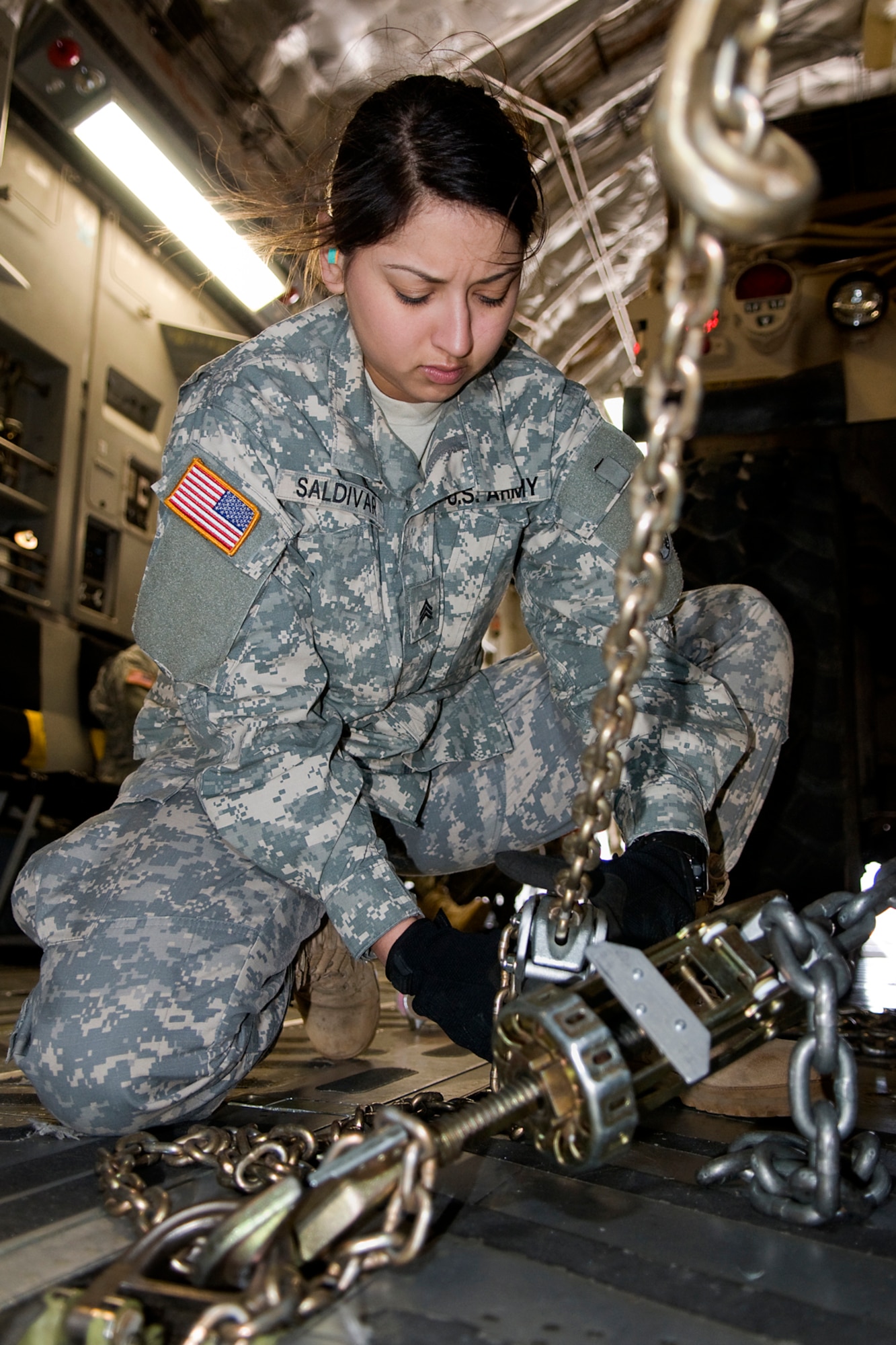 U.S. Army Sgt. Sandy Saldivar, 766th Transportation Battalion motor transport operator, chains down a Humvee in a C-17 Globemaster III aircraft at Grissom Air Reserve Base, Ind., May 3, 2014. Airmen of Grissom's 49th Aerial Port Squadron and Airmen from the 89th Airlift Squadron, based at Wright-Patterson Air Force Base, Ohio, took a day to show 766th BN Soldiers how to build cargo pallets for airlift and how to load a Humvee and a HEMTT into a C-17 Globemaster III aircraft. (U.S. Air Force photo/Tech. Sgt. Mark R. W. Orders-Woempner)
