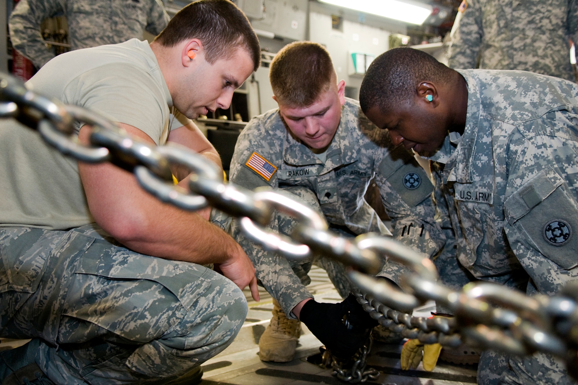 U.S. Air Force Staff Sgt. Skyles Fullenkamp, 49th Aerial Port Flight aerial port specialist, shows Soldiers of the U.S. Army Reserve's 766th Transportation Battalion how to tie down a Humvee on a C-17 Globemaster III aircraft at Grissom Air Reserve Base, Ind., May 3. 2014. Airmen of Grissom' 49th APF and Airmen from the 89th AS, based at Wright-Patterson Air Force Base, Ohio, took a day to show 766th BN Soldiers how to build cargo pallets for airlift and how to load a Humvee and a heavy expanded mobility tactical truck into a C-17 Globemaster III aircraft. (U.S. Air Force photo/Tech. Sgt. Mark R. W. Orders-Woempner)
