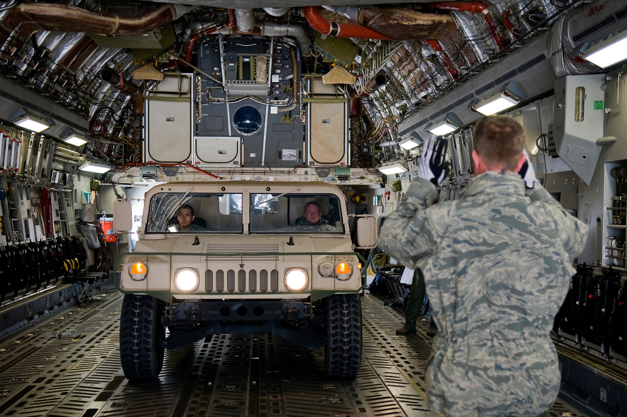 A U.S. Air Force loadmaster from the 89th Airlift Squadron directs Soldiers of the U.S. Army Reserve's 766th Transportation Battalion as they load a Humvee on a C-17 Globemaster III aircraft at Grissom Air Reserve Base, Ind., May 3. 2014. Airmen of Grissom's 49th Aerial Port Squadron and Airmen from the 89th AS, based at Wright-Patterson Air Force Base, Ohio, took a day to show 766th BN Soldiers how to build cargo pallets for airlift and how to load a Humvee and a heavy expanded mobility tactical truck into a C-17 Globemaster III aircraft. (U.S. Air Force photo/Tech. Sgt. Mark R. W. Orders-Woempner)

