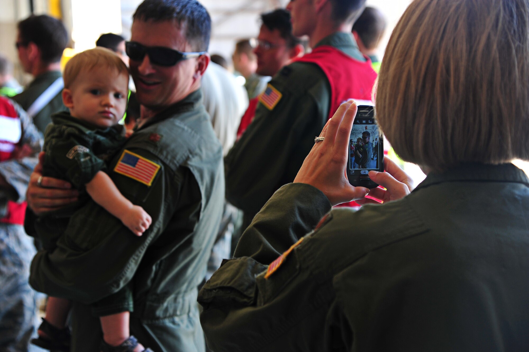 Maj. Jamie Krassow, 1st Special Operations Aerospace Medicine Squadron flight surgeon, captures a moment with her family during Operation Homecoming at Hurlburt Field, Fla., July 4, 2014. Families and friends greeted their loved ones as they returned home from deployed locations. (U.S. Air Force photo/Senior Airman Desiree W. Moye)