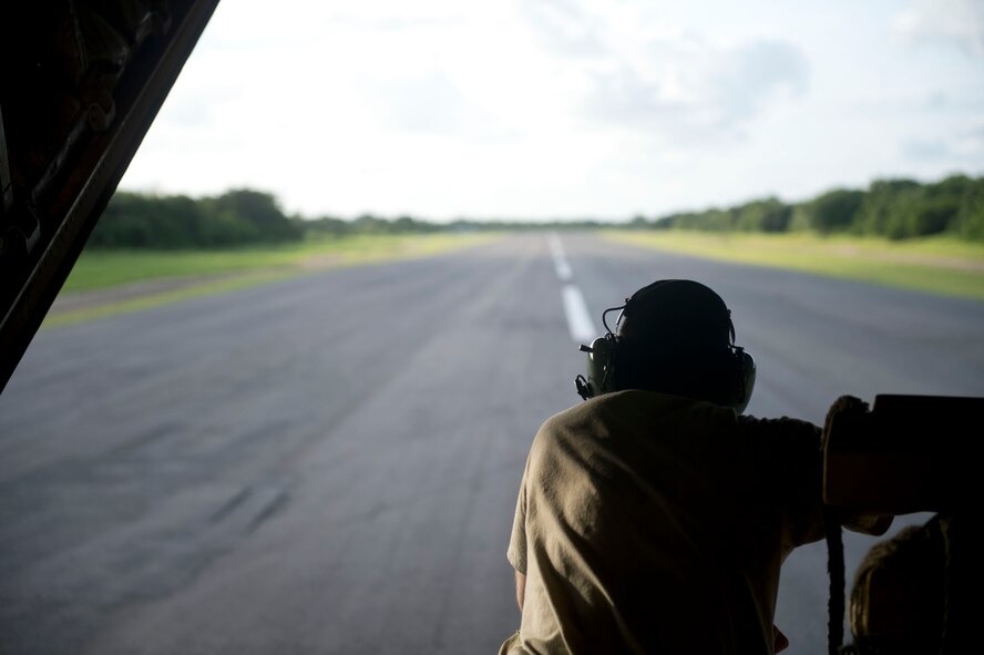 Senior Airman Calvin Cox, 75th Expeditionary Airlift Squadron C-130J Super Hercules loadmaster, directs the pilot while the aircraft is back-taxiing June 21, 2014, in East Africa. The C-130J crew was transporting personnel and equipment in support of Combined Joint Task Force-Horn of Africa's mission of stabilizing and strengthening security in East Africa. (U.S. Air Force photo by Senior Airman Riley Johnson)