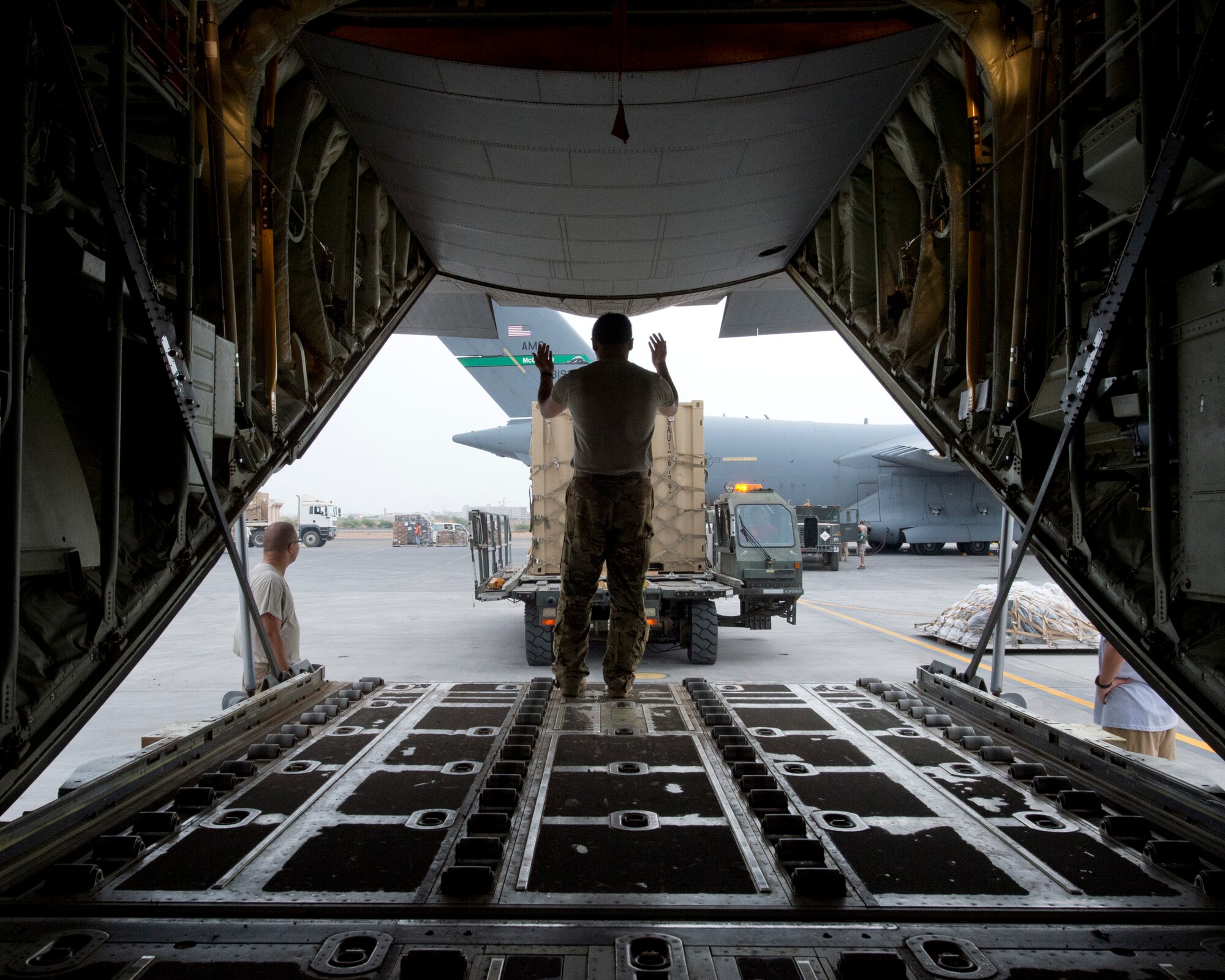 Senior Airman Dan Cabanas, 75th Expeditionary Airlift Squadron, directs the movement of cargo onto the C-130J June 11, 2014 at Camp Lemonnier, Djibouti. The C-130J crew was transporting personnel and equipment in support of Combined Joint Task Force-Horn of Africa's mission of stabilizing and strengthening security in East Africa. (U.S. Air Force photo by Staff Sgt. Leslie Keopka)