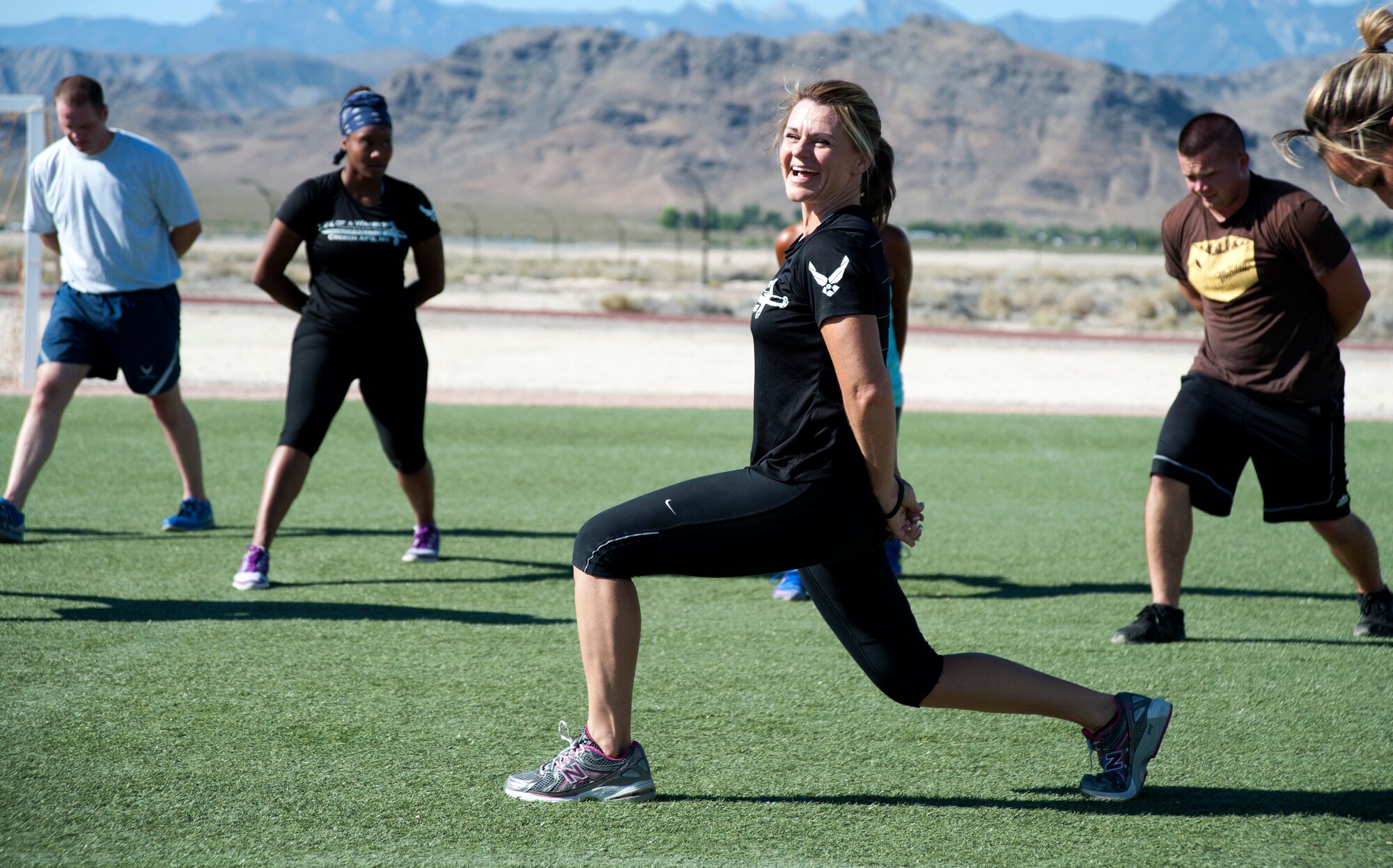 Missy Cornish, wife of Col. Barry Cornish, 99th Air Base Wing commander, leads Creech Airmen in a warm-up exercise during her last instruction of a Warrior Trained Fitness event June 23, 2014, at Creech Air Force Base, Nev. Cornish has led the Warrior Trained Fitness events since its inception in October 2013. (U.S. Air Force photo by Tech. Sgt. Shad Eidson/Released)