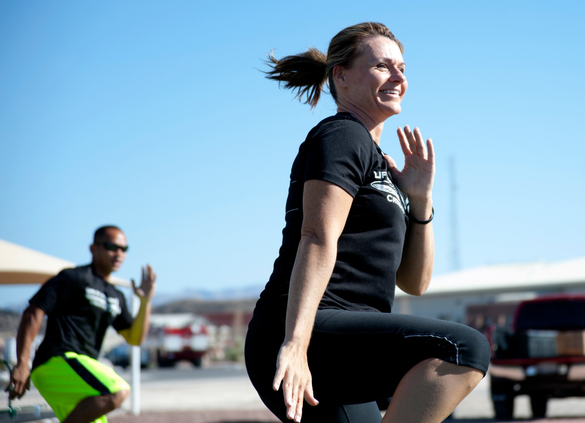 Missy Cornish, wife of Col. Barry Cornish, 99th Air Base Wing commander, leads Creech Airmen in a warm-up exercise during her last instruction of a Warrior Trained Fitness event June 23, 2014, at Creech Air Force Base, Nev. Cornish has led the Warrior Trained Fitness events since its inception in October 2013. (U.S. Air Force photo by Tech. Sgt. Shad Eidson/Released)